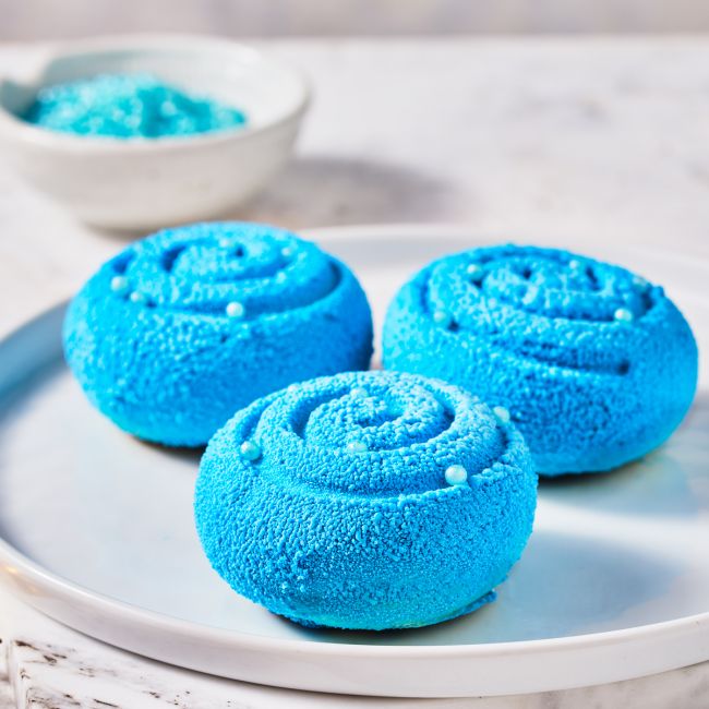 Minikuchen mit Velvet Spray Himmelblau auf weißem Teller