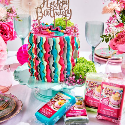 Fondant Torte mit CakeTopper in bunt mit farbigen Fondant Packungen im Vordergrund