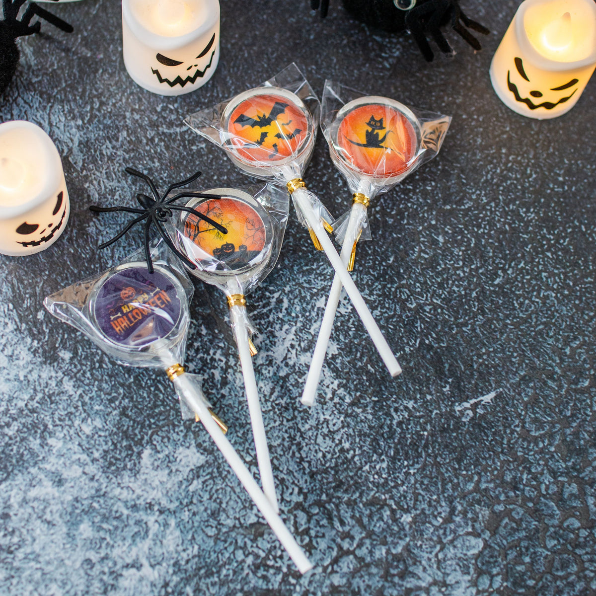 Halloween Lollis orange schwarz, 4 Motive als Beispiel mit Geisterkerzen