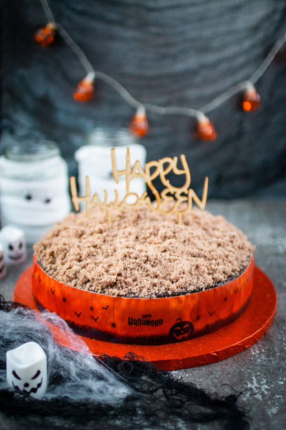 Halloween Tortenband auf Torte mit Kuchenstreuseln und CakeTopper Happy Halloween vor dunkler Wand