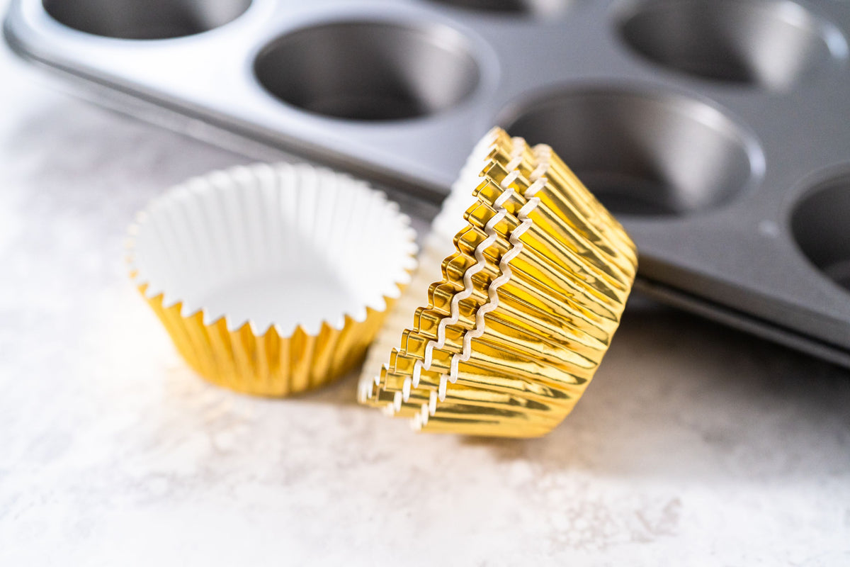 HoM Muffinförmchen in gold glänzend vor Muffinblech